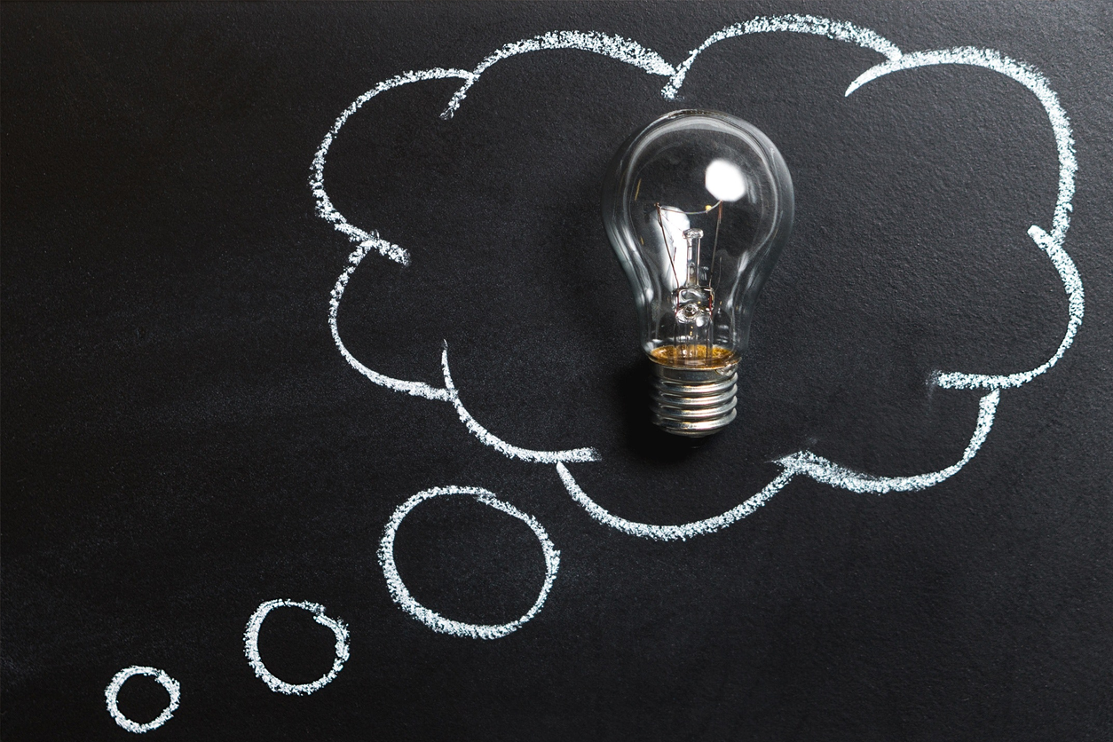 Cloud drawing on chalk board with lightbulb inside of it.